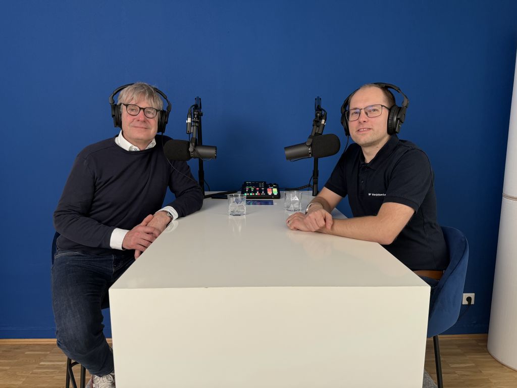 Dr. Christian Felten und Stefan Ganzke mit Kopfhörern an einem Tisch vor Mikrophonen