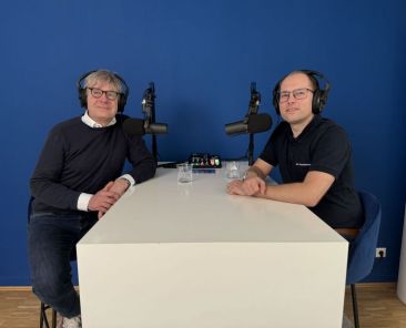 Dr. Christian Felten und Stefan Ganzke mit Kopfhörern an einem Tisch vor Mikrophonen